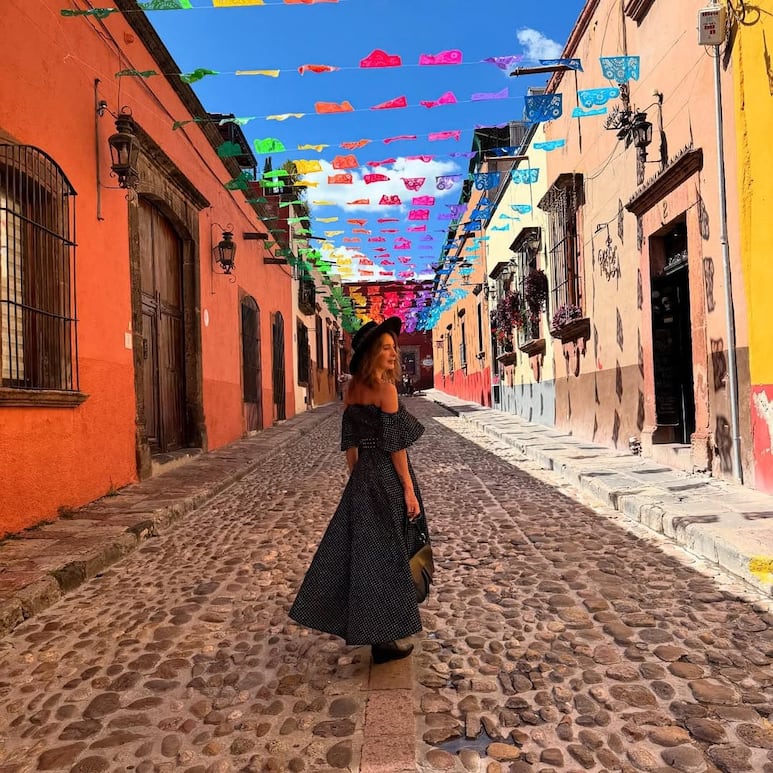Geraldine Bazán en look boho chic con botas vaqueras caminando por una calle de San Miguel de Allende