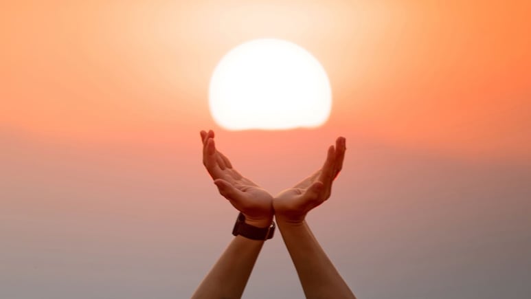 Mujer recibiendo la luz del solsticio en su casa con energía positiva